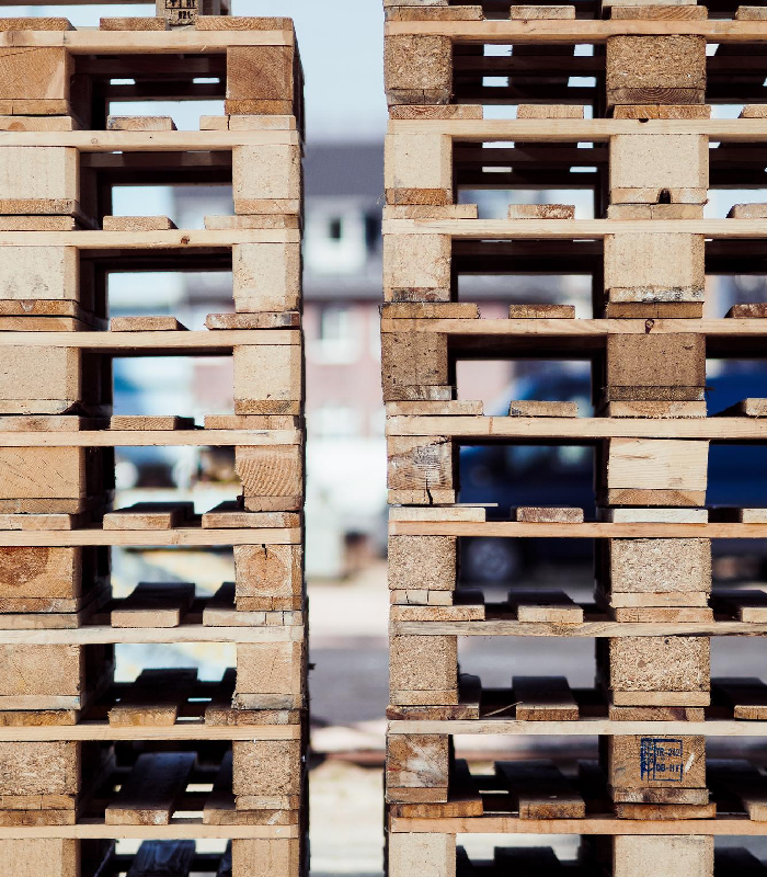 Palettes standards en bois empilées pour transport et stockage chez Center Euro Palettes